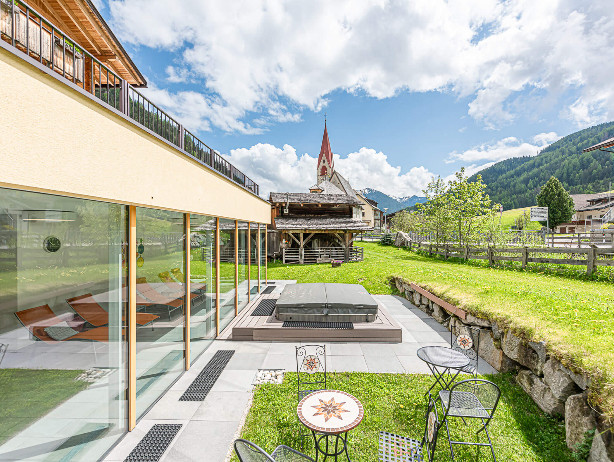 Terrace of the Berghotel Alpenfrieden with view of the church tower of Rio Bianco