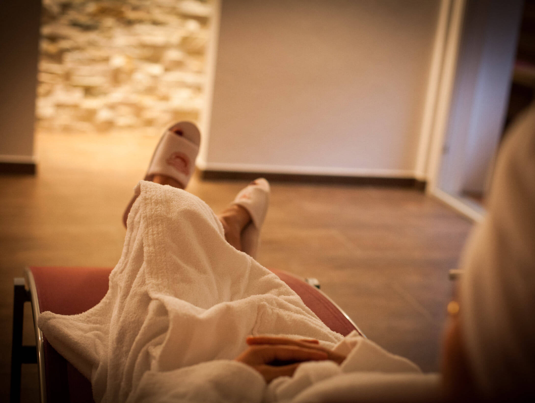 Woman relaxing on a lounger in the wellness area - Berghotel Alpenfrieden