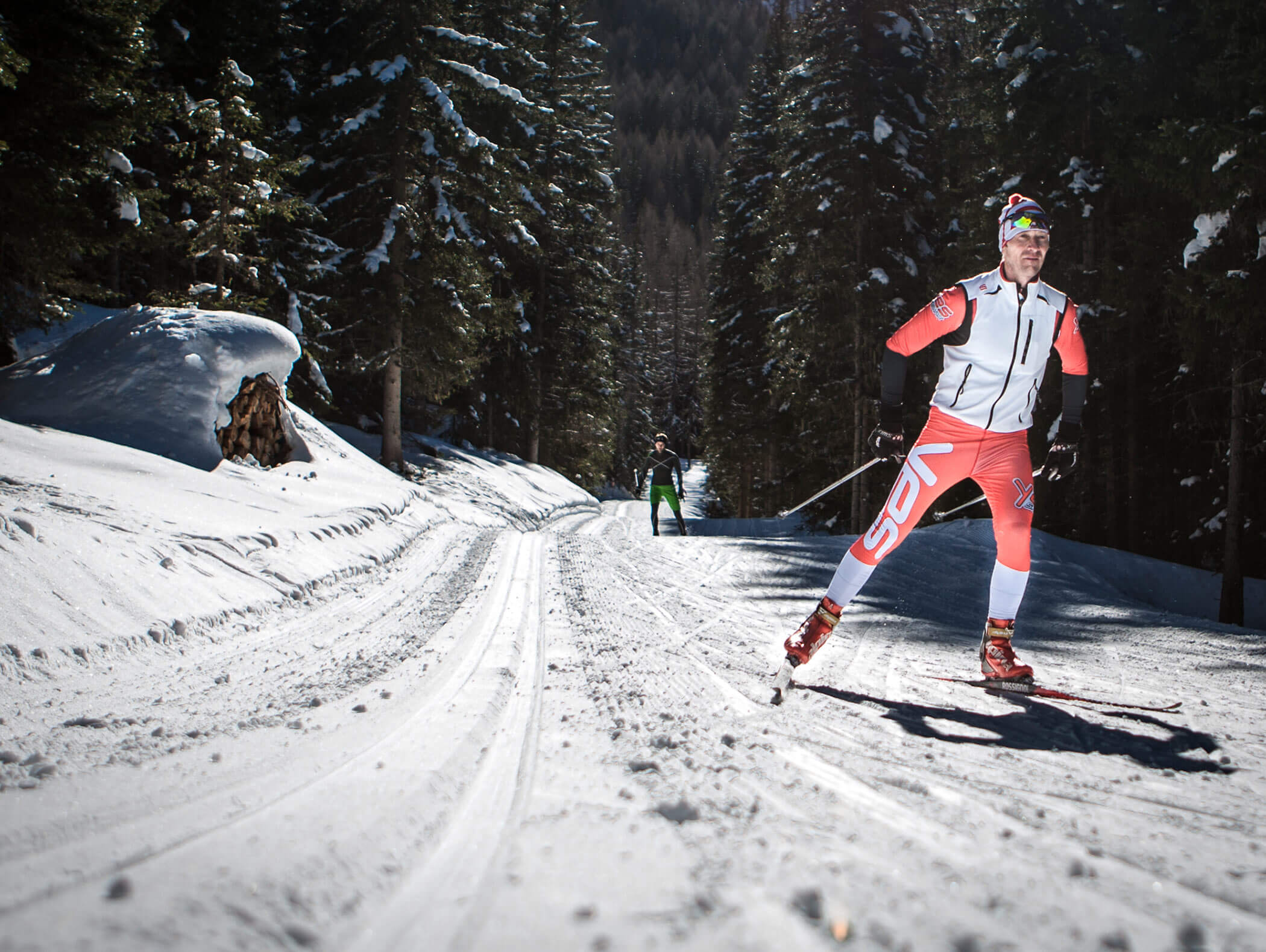 Two men on the cross-country trail between snow-covered trees - Berghotel Alpenfrieden