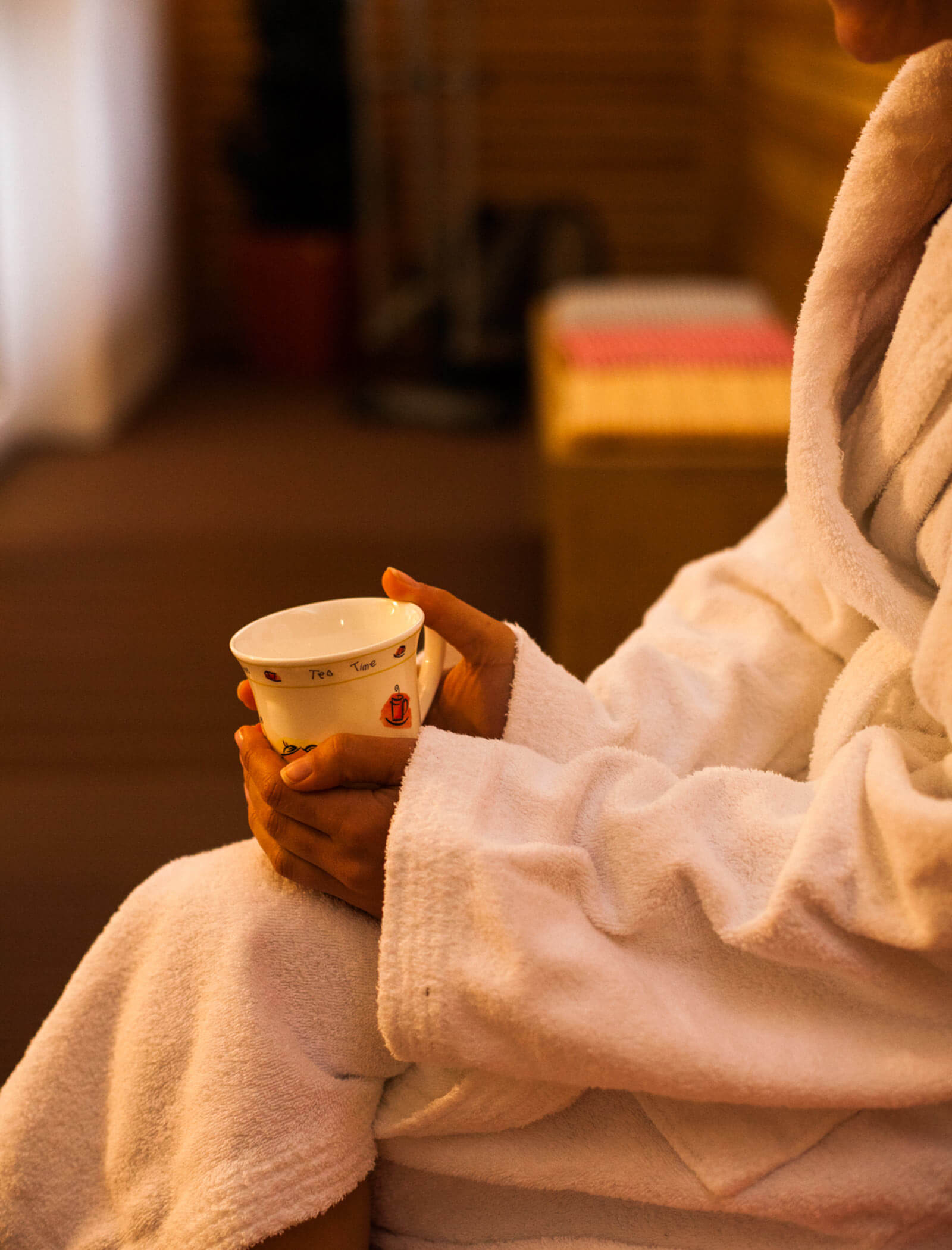 Woman in a bathrobe warms up with a cup of tea - Berghotel Alpenfrieden