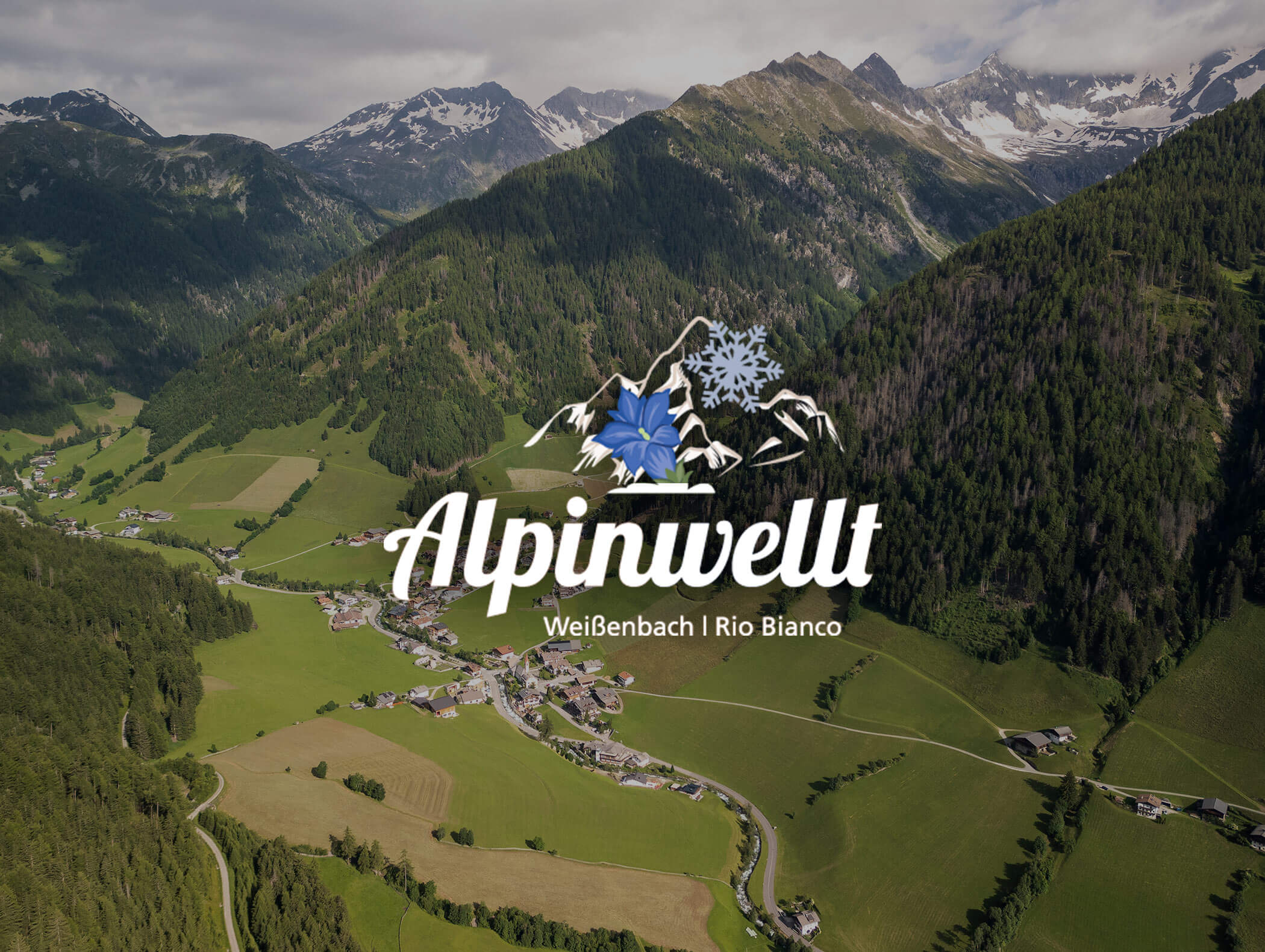 Logo of Alpinwelt Weißenbach | Rio Bianco and a bird's eye view of the village of Rio Bianco in the background - Berghotel Alpenfrieden