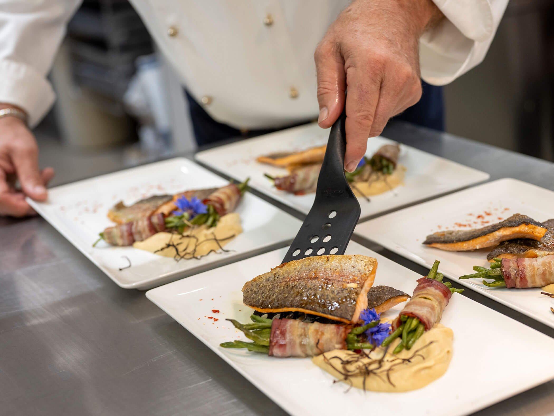 Chef arranges fish on the plates