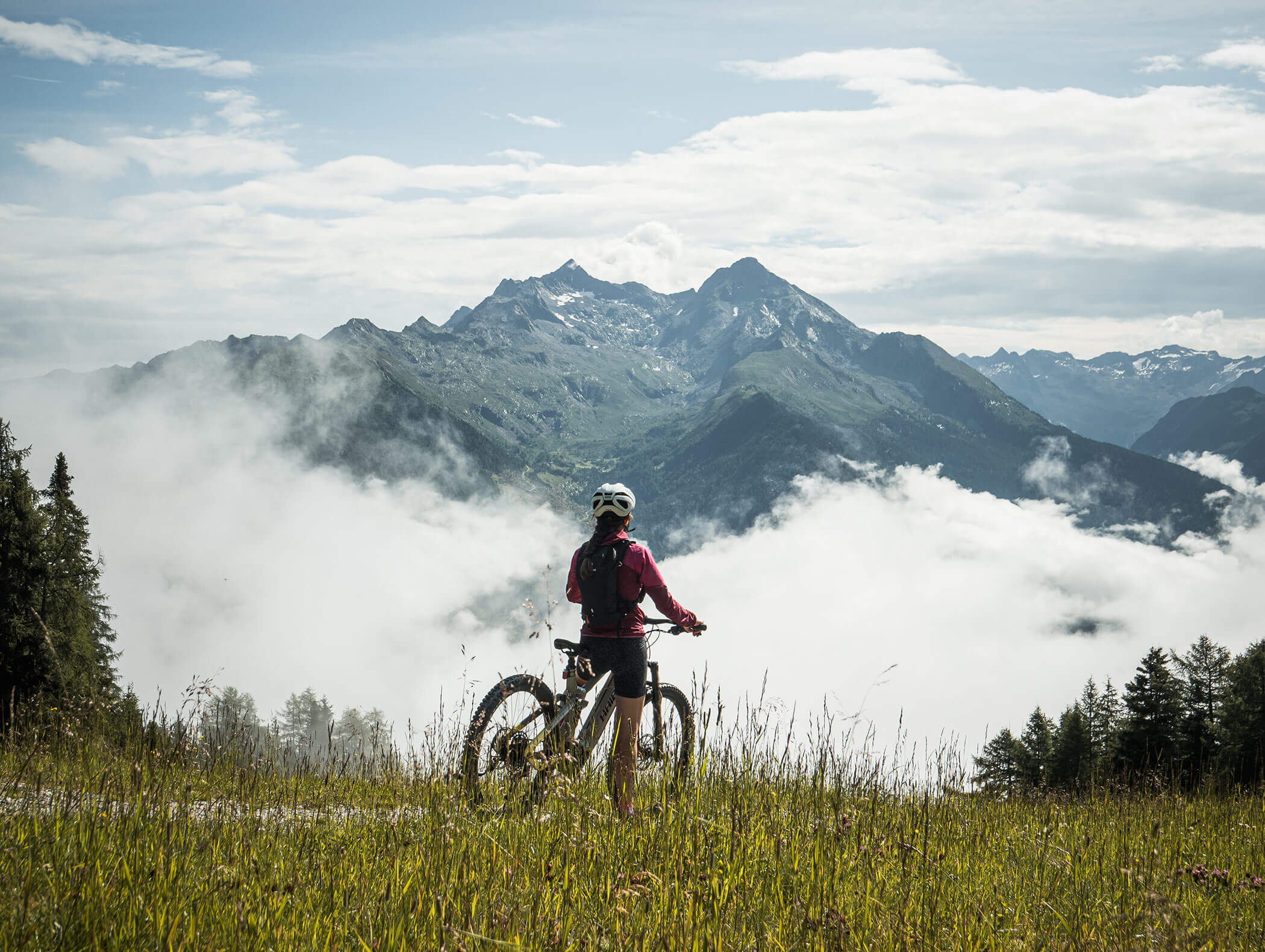 Radfahrerin genießt die Bergwelt bei einer Pause - Berghotel Alpenfrieden