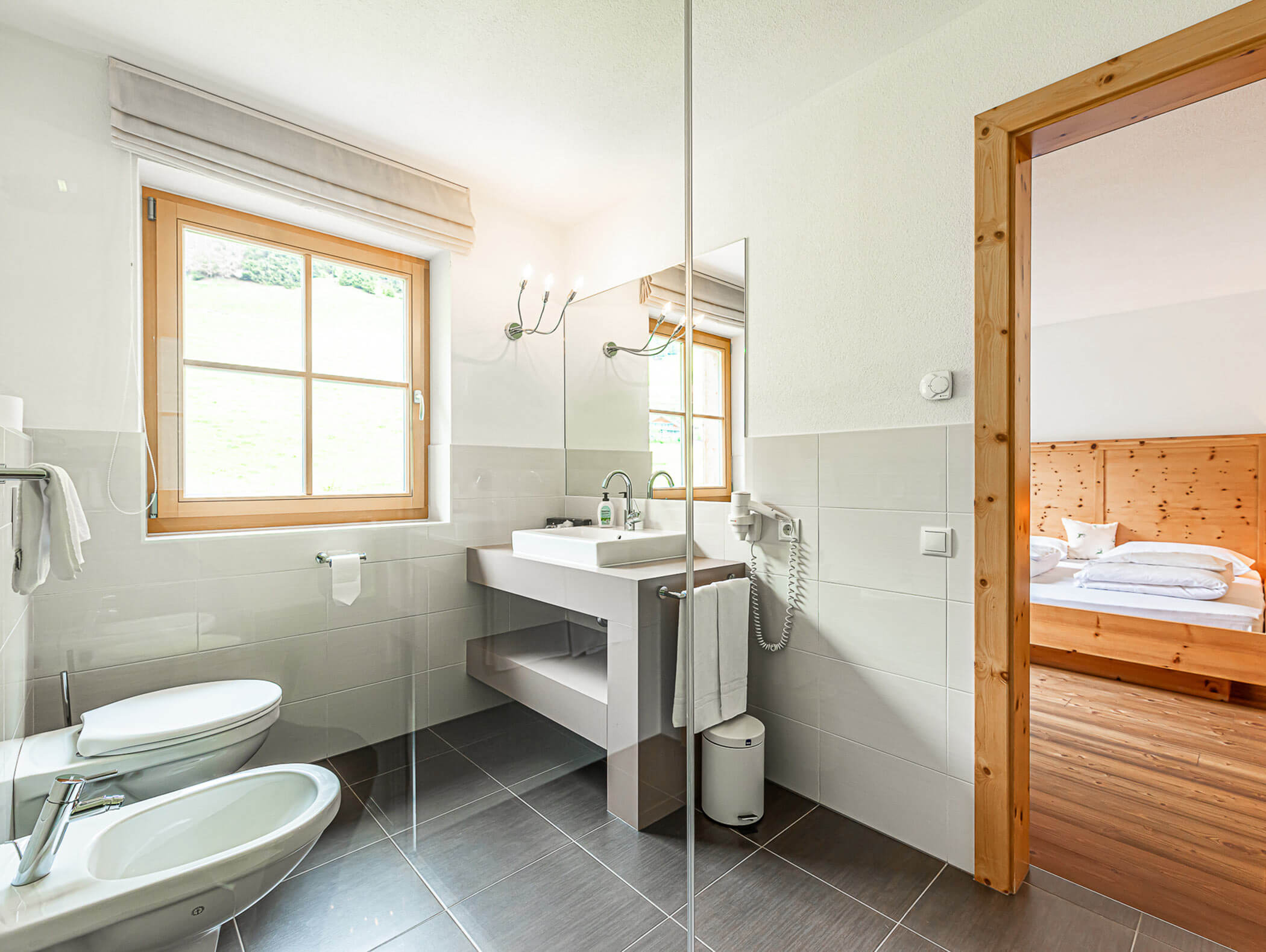 Badezimmer vom Dependance Deluxe Zimmer mit WC, Waschbecken, Spiegel und Dusche - Berghotel Alpenfrieden