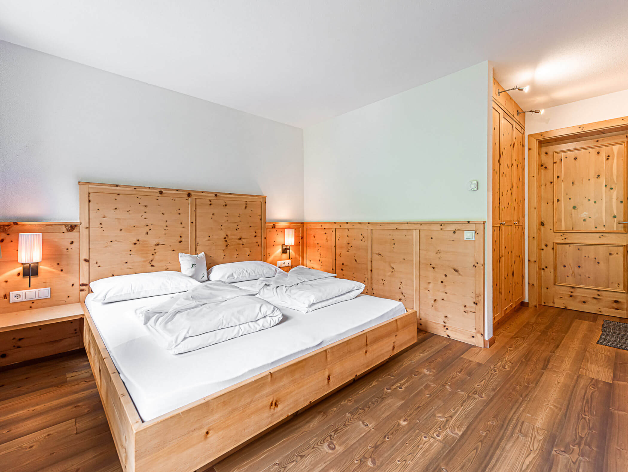 Dependance Deluxe Zimmer aus Holz mit hellem Doppelbett - Berghotel Alpenfrieden