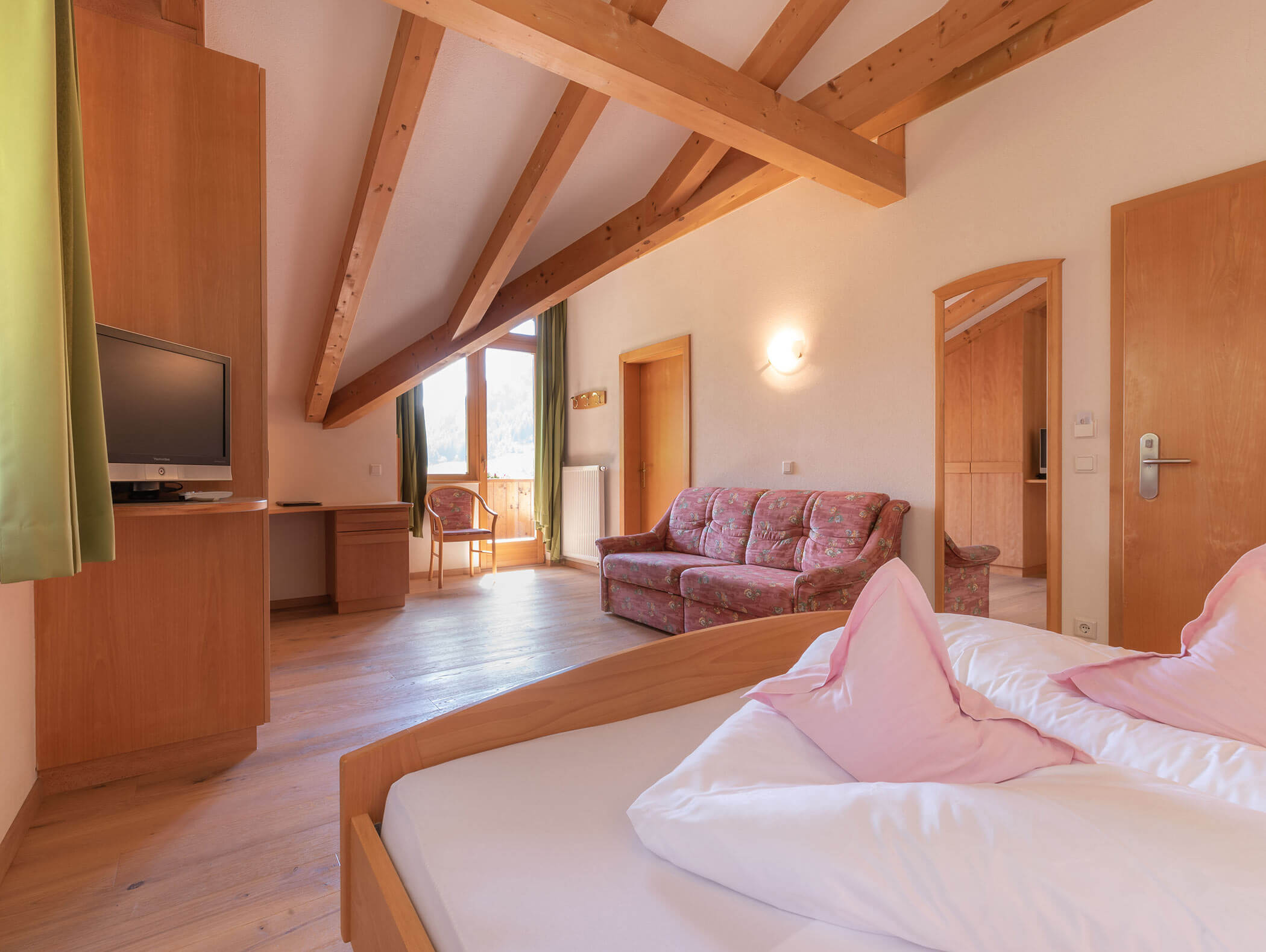 Helles Standardzimmer mit Doppelbett, Sofa und TV - Berghotel Alpenfrieden