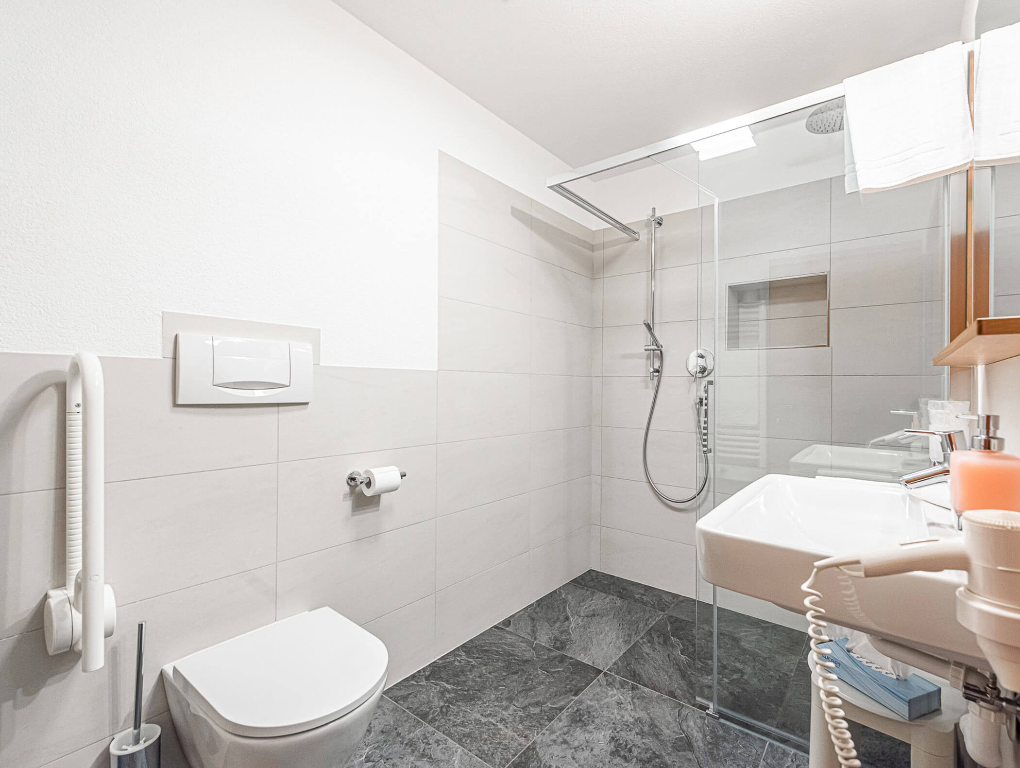 Badezimmer im Berghotel Superior Zimmer mit großer Regendusch, Waschbecken und WC - Berghotel Alpenfrieden